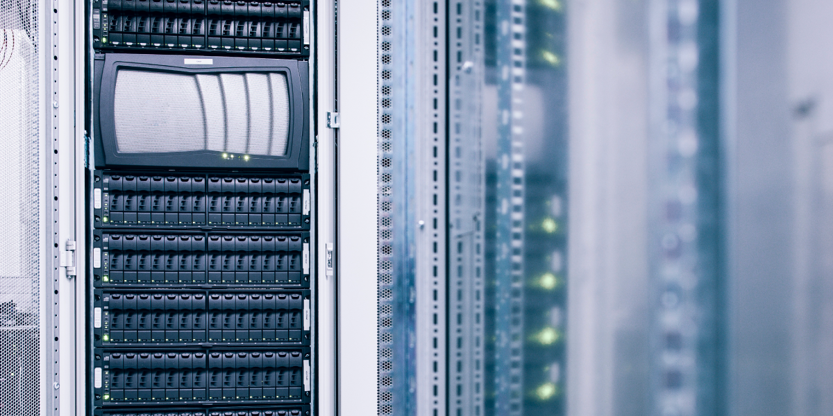 A close-up of server racks in a data center, showing rows of black hardware with indicator lights and a monitor screen on one rack. The image is cool-toned, with a modern, high-tech feel—ideal for High-Pulsed Current Testing environments. by Standex Detect