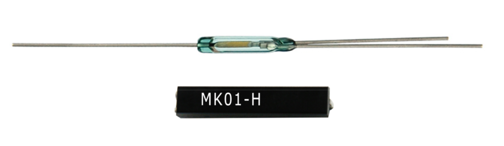 A glass Form C reed switch with two metal leads is shown above a small black rectangular electronic component labeled MK01-H in white text from Standex. by Standex Detect